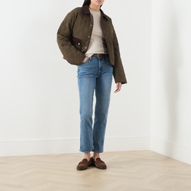 Model wearing Paige Fern quilted jacket with cream top, blue straight-leg jeans and brown loafers