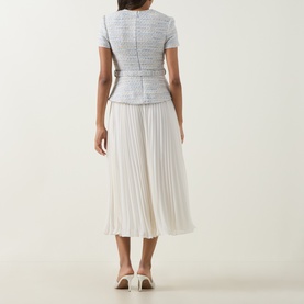 Model wearing Self-Portrait blue tweed-style top and pleated midi skirt dress, back view, styled with cream heeled mules