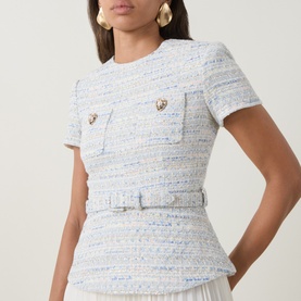 Model wearing Self-Portrait blue tweed mini dress with short sleeves, chest pockets, jewel buttons, and belted peplum waist detail.