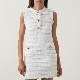 Model wearing Self-Portrait white sleeveless tweed mini dress with jewel buttons and frayed trim detailing