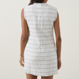 Model wearing Self-Portrait white cotton tweed mini dress, sleeveless with frayed stripe detailing, shown from the back