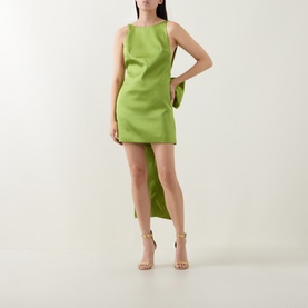 Model wearing Self-Portrait green sleeveless mini dress with asymmetric hem, styled with nude heeled sandals and matching green clutch bag.