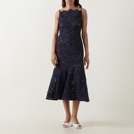 Model wearing Self-Portrait navy lace midi dress with fluted hem, scallop neckline and strappy design, styled with white heeled mules.