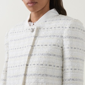 Model wearing Self-Portrait white cotton tweed jacket with metallic stripe detail and pearl button fastening, styled with white collared top