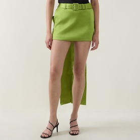 Model wearing Self-Portrait green asymmetric mini skirt with belt detail, styled with black strappy heeled sandals