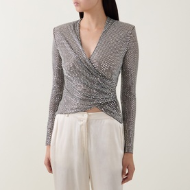 Model wearing Self-Portrait grey crystal-embellished wrap top with long sleeves and ruched front, styled with white wide-leg trousers