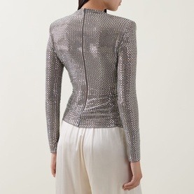 Model wearing Self-Portrait grey sequin embellished long-sleeve top, styled with cream wide-leg trousers, rear view.