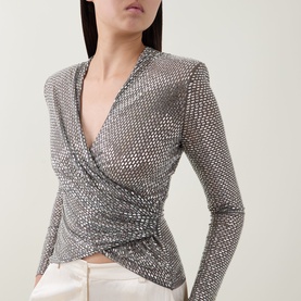 Model wearing Self-Portrait grey embellished wrap-style long-sleeve top with deep V-neckline and ruched front detail, styled with white trousers.