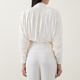 Model wearing Self-Portrait cream ruched top, back view, with matching cream wide-leg trousers. Gathered fabric detail, ribbed hem and cuffs.