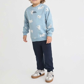 Model wearing Street Monkey light blue polar bear print sweatshirt and navy joggers two-piece set, styled with white trainers