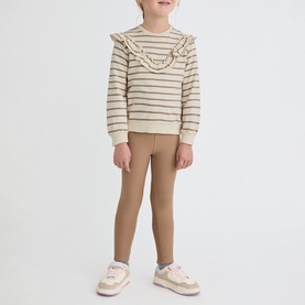 Model wearing Street Monkey Ecru 2 Piece Set, striped ruffle sweatshirt with tan leggings and pink trainers