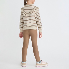 Model wearing Street Monkey Ecru 2 Piece set; striped ruffle-trim hoodie and tan leggings, styled with pink trainers