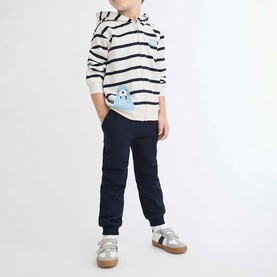 Model wearing Street Monkey Ecru 2 Piece set, navy striped hoodie with monster appliqu&eacute; and navy joggers, styled with silver trainers.