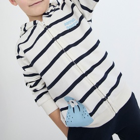 Model wearing Street Monkey ecru navy stripe zip-up hoodie, part of 2-piece baby set, with light blue character detail at hem
