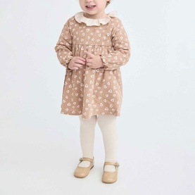 Model wearing Street Monkey brown floral dress with frill collar, styled with cream leggings and gold mary jane shoes
