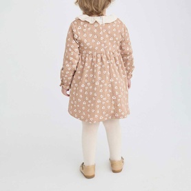 Model wearing Street Monkey brown floral dress with white peter pan collar, long sleeves, styled with cream tights and gold shoes