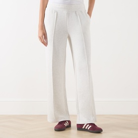 Model wearing Varley Ivory Marl wide-leg sweat bottoms with elasticated waist, styled with burgundy and white trainers.