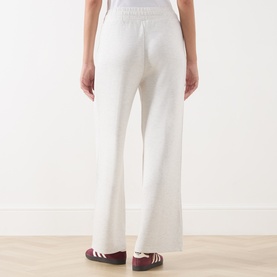 Model wearing Varley Ivory Marl sweat bottoms, rear view, wide-leg knit style with elasticated waist, styled with burgundy trainers.