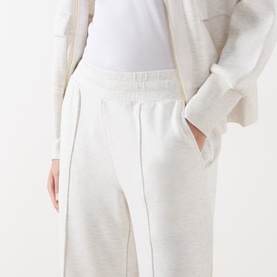 Model wearing Varley Ivory Marl sweat bottoms with elasticated waist and front seam detail, styled with a white top and cream cardigan.