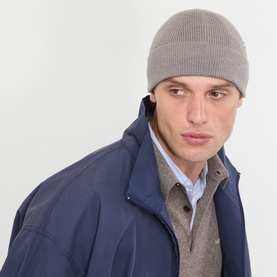 Model with Acne Metal Logo Beanie Hat in warm grey melange; ribbed knit with turned-up brim, styled with navy jacket