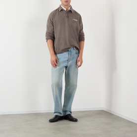 Model wearing Acne Logo Knitted Polo Sweater in brown melange with light wash straight-leg jeans and black leather shoes.