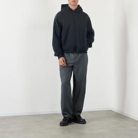 Model wearing Acne black cotton hoodie sweatshirt, styled with grey tailored trousers and black loafers