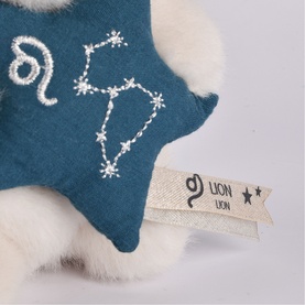 Histoire d'Ours soft plush toy with teal star featuring embroidered Leo constellation and stitched zodiac symbol, cream fur detail visible
