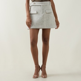 Model wearing Odd Muse grey wool mini skirt with patch pockets, styled with nude strappy heeled sandals.