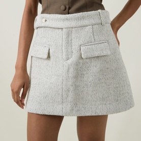 Model wearing Odd Muse grey wool mini skirt with flap pockets, styled with a brown button-up top.