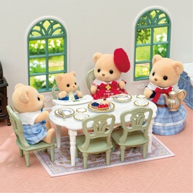 Sylvanian Families bear figures seated around oval dining table with green chairs, tea set, and cake on floral rug