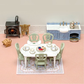 Sylvanian Families dollhouse dining set with green table and chairs, kitchen unit, stove, and miniature accessories on a pink floral rug
