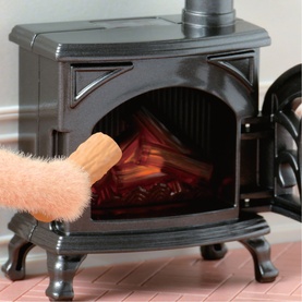 Sylvanian Families miniature black wood-burning stove accessory with glowing fire effect, shown with small brush detail