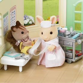 Sylvanian Families dental playset with rabbit dentist figure, hedgehog patient, treatment chair, and medical trolley accessories in pink and brown