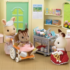 Sylvanian Families playset with rabbit figures, wheelchair, medical trolley, and accessories in a colourful room setting