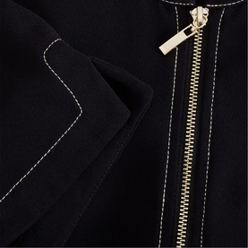 Phase Eight black dress close-up detail showing gold zip and contrast white stitching trim