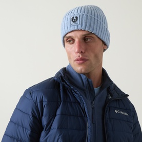 Model with Belstaff Watch Logo Beanie Hat in Mist Blue ribbed wool, logo patch on turned-up brim, styled with navy quilted jacket