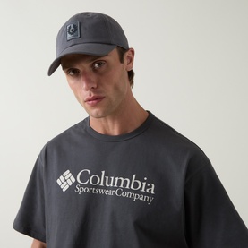 Model with Belstaff Phoenix Logo Baseball Cap in Petrol, curved visor, front logo patch, styled with Columbia graphic T-shirt