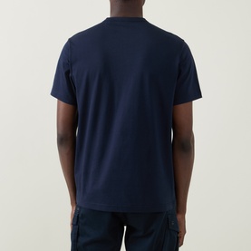 Model wearing Belstaff Phoenix Logo T-Shirt in Dark Ink, rear view showing crew neck, short sleeves, and straight hem. Styled with navy cargo