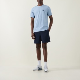 Model wearing Belstaff Phoenix Logo T-Shirt in Mist Blue with navy shorts, white socks and grey trainers.