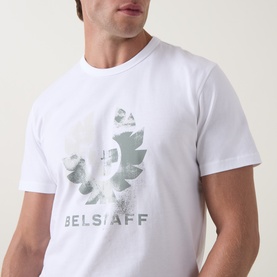 Model wearing Belstaff Blur Logo T-Shirt in white, featuring a faded camo phoenix graphic and Belstaff lettering at chest.