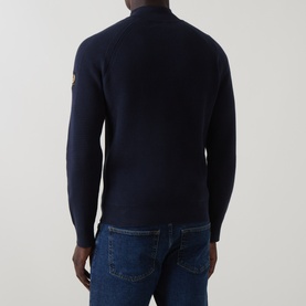 Model wearing Belstaff Dark Ink cotton half zip jumper, rear view, styled with blue denim jeans. Gold arm badge visible.
