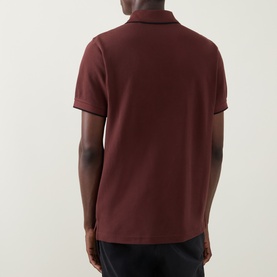 Model wearing Belstaff Phoenix Logo Tipped Polo Shirt in oxblood, back view showing contrast tipping and straight hem with side splits.