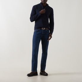 Model wearing Belstaff 3049 Straight Jeans in Washed Indigo, styled with a navy zip-neck jumper and dark loafers with a brown belt.
