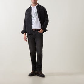 Model wearing Belstaff B69 Straight-Leg Jeans in Washed Black with a white graphic tee, black denim jacket, and dark boots.
