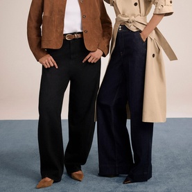 Two models wearing Mint Velvet wide-leg black trousers; one styled with a brown suede jacket, the other with a beige trench coat