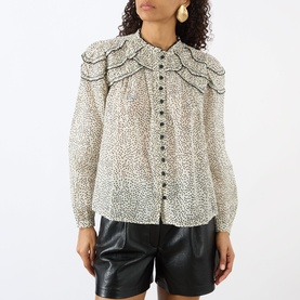 Model wearing Isabel Marant Etoile ecru and black spot-print blouse with oversized ruffle collar, puff sleeves, and button front, styled with black