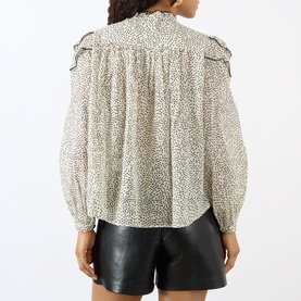 Model wearing Isabel Marant Etoile ecru and black spot-print cotton blouse with ruffle shoulders and balloon sleeves, styled with black leather