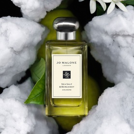 Jo Malone London Sea Salt & Bergamot Cologne in clear glass bottle with silver cap, styled with white flowers and green leaves