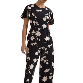 Model wearing Phase Eight black ivory floral print short sleeve wide-leg jumpsuit with tie waist