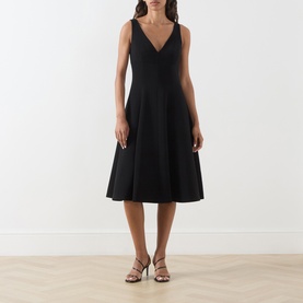 Model wearing Max Mara Studio black sleeveless V-neck midi dress with flared skirt, styled with strappy heeled sandals.
